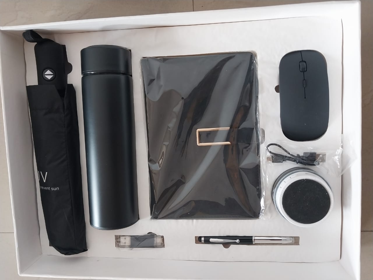 Executive 7 in 1 Corporate Gift Set –MOQ 50pcs Premium 7 in 1 corporate gift set of · Umbrella · Bottle flask · Wireless mouse · Leather Notepad · Bluetooth speaker · Flash drive · Ball Pen · All in a well packaged box Readily available in stock -MOQ-50pcs Consists 1 Hot/Cold Temperature Vacuum Flask , 1 Executive Pen 1 Bluetooth speaker 1 Wireless Mouse 1 16gb flash drive 1 diary/notepad , 1 umbrella . Colours Available: Black , Blue , Gold . Item available in large quantities . Branding/ Customization services also available